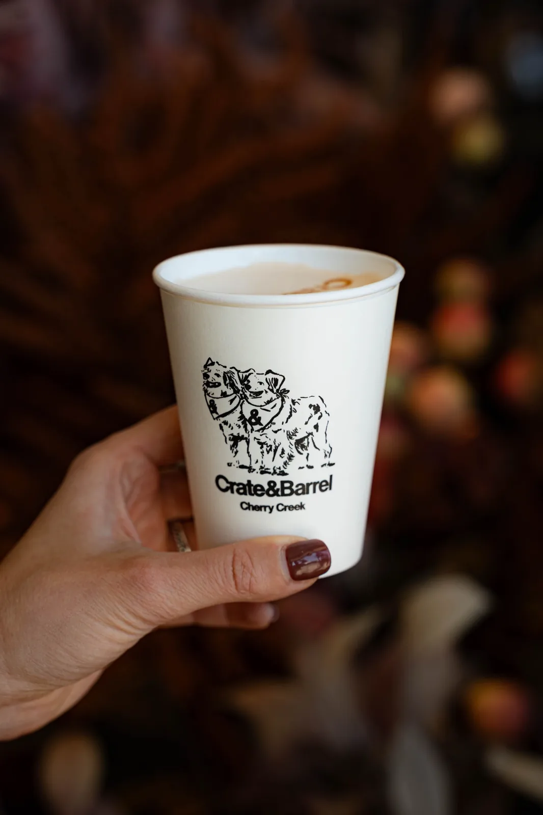 A latte in a Crate and Barrel branded cup