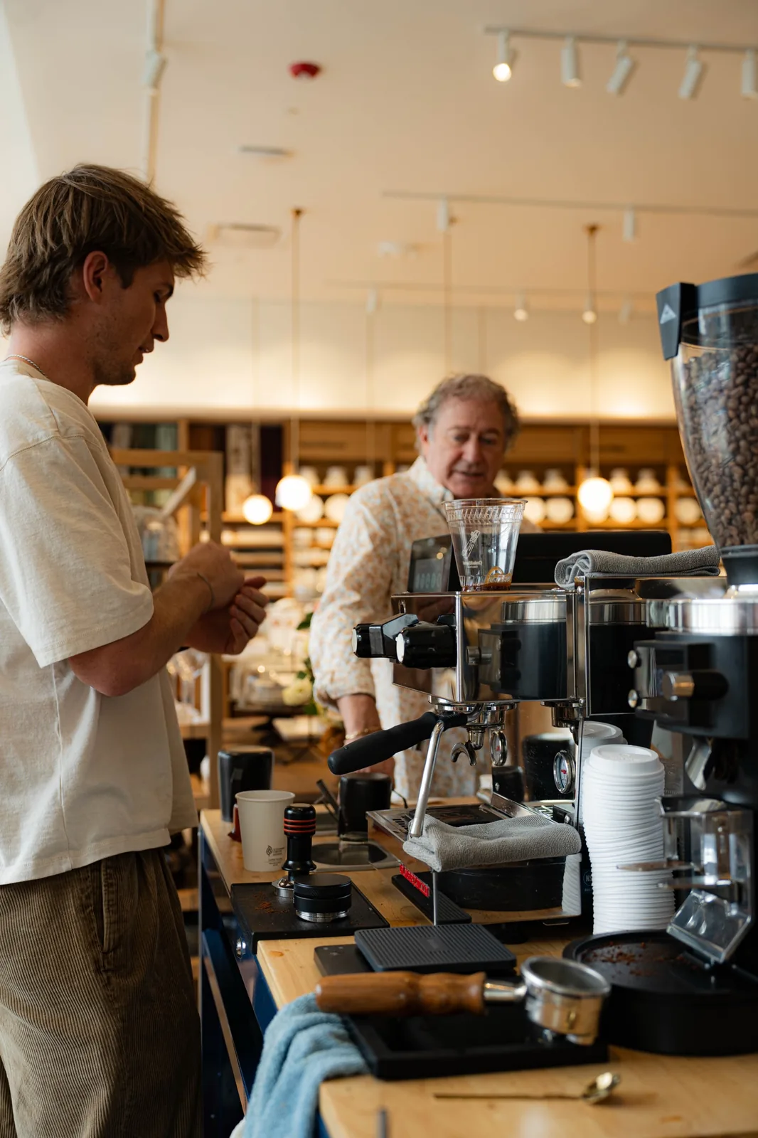 A barista handing a drink across the cart to a guest at a store event